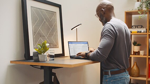 man working on laptop at standing desk